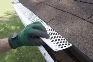 Contractor Adjusting Plastic Gutter Guards- Big Easy Roofing