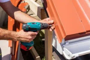 man installing metal roof