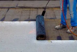 worker preparing part of bitumen felt roll