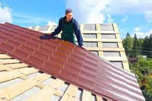man laying metal roof