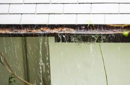 rainwater overflowing from a clogged gutter