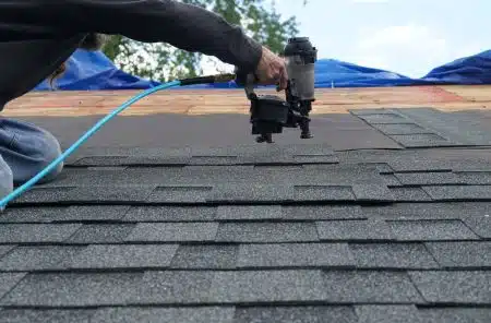 man working on the roof using a hand tool