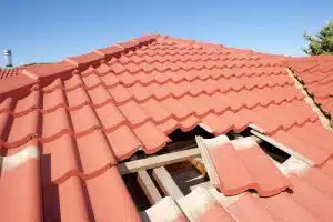 Damaged red tile roof construction house - Big Easy Roofing