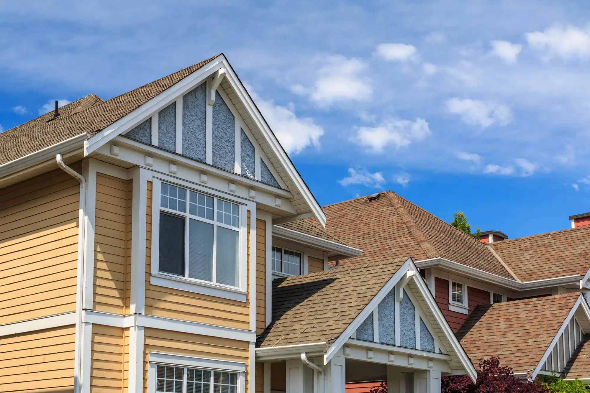 Residential homes with newly replaced architectural asphalt shingle roofs