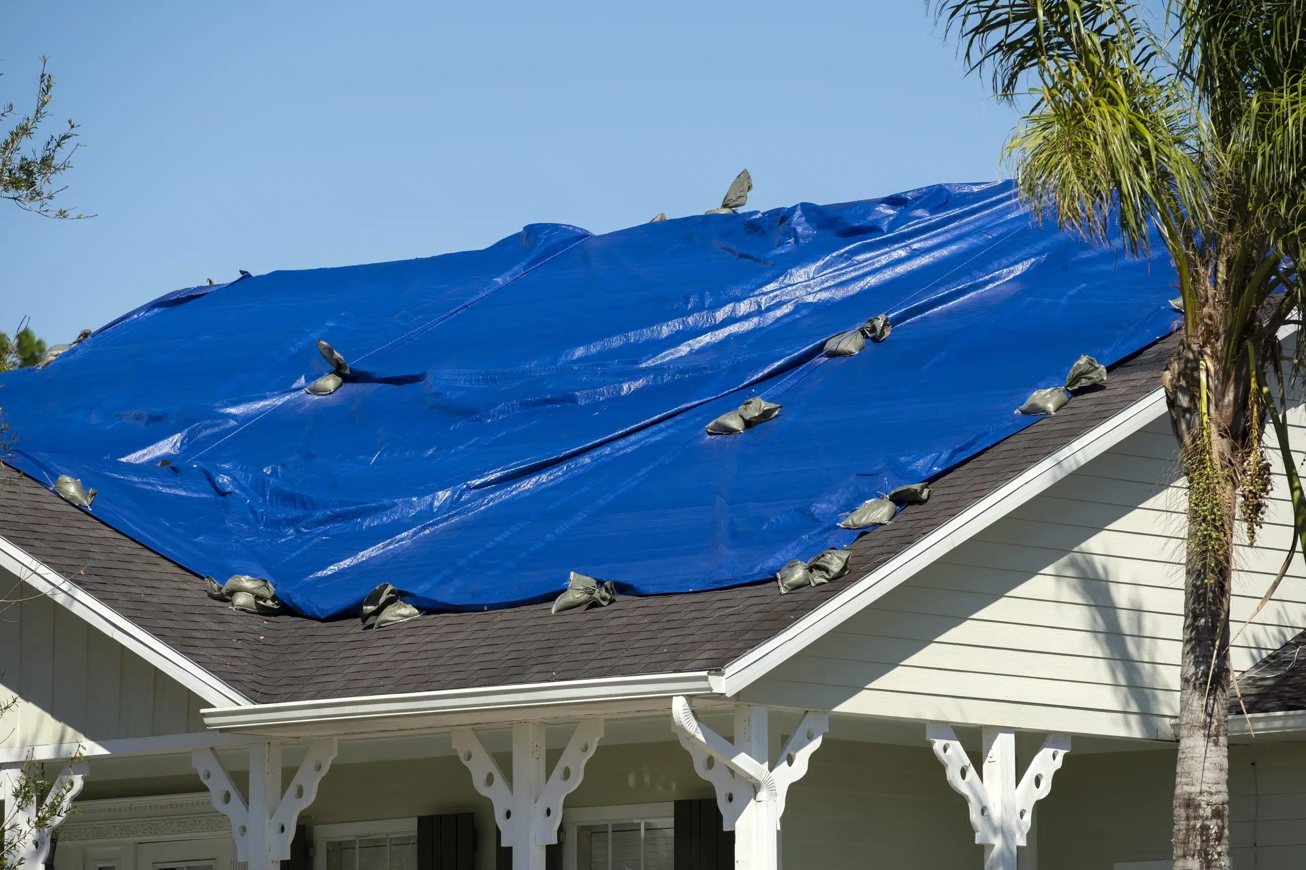 Blue tarp covering storm-damaged roof in New Orleans neighborhood