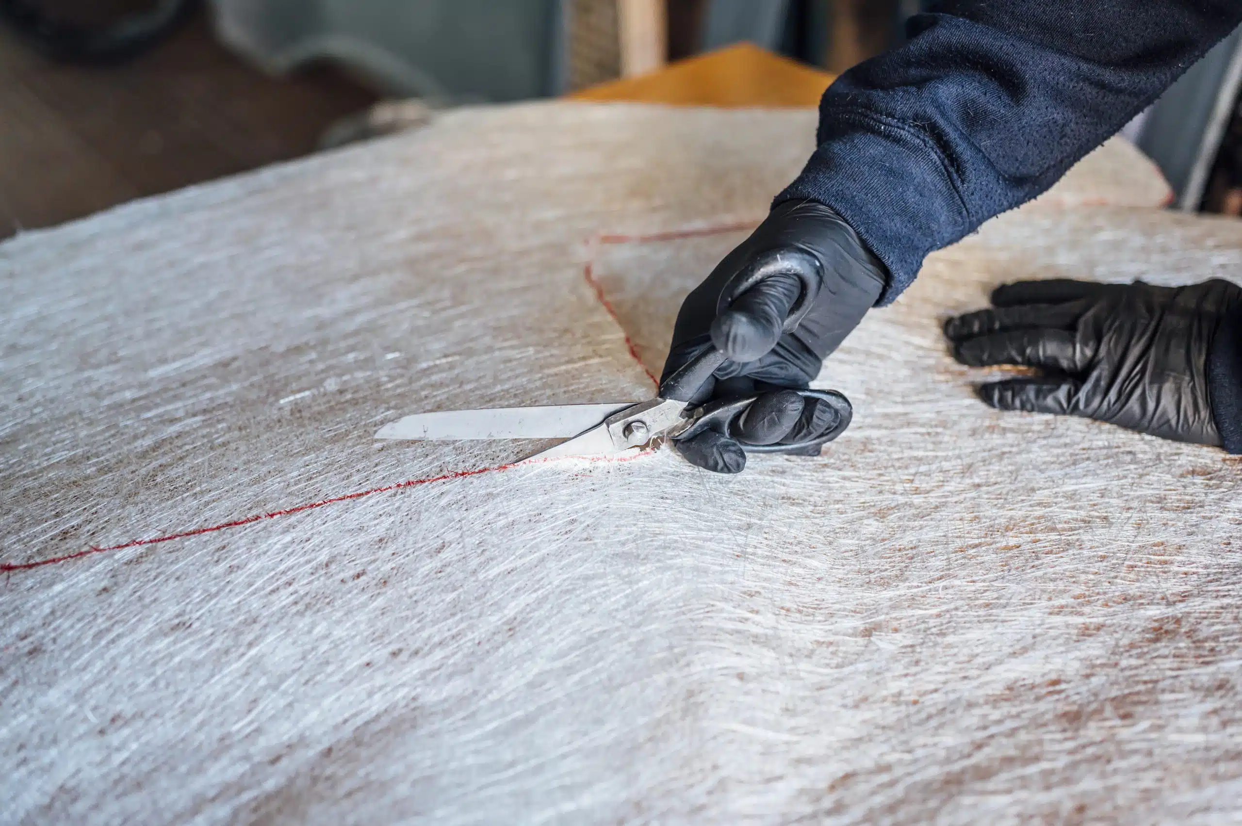 Roofer performing a core cut sample on a commercial flat roof to check insulation moisture levels